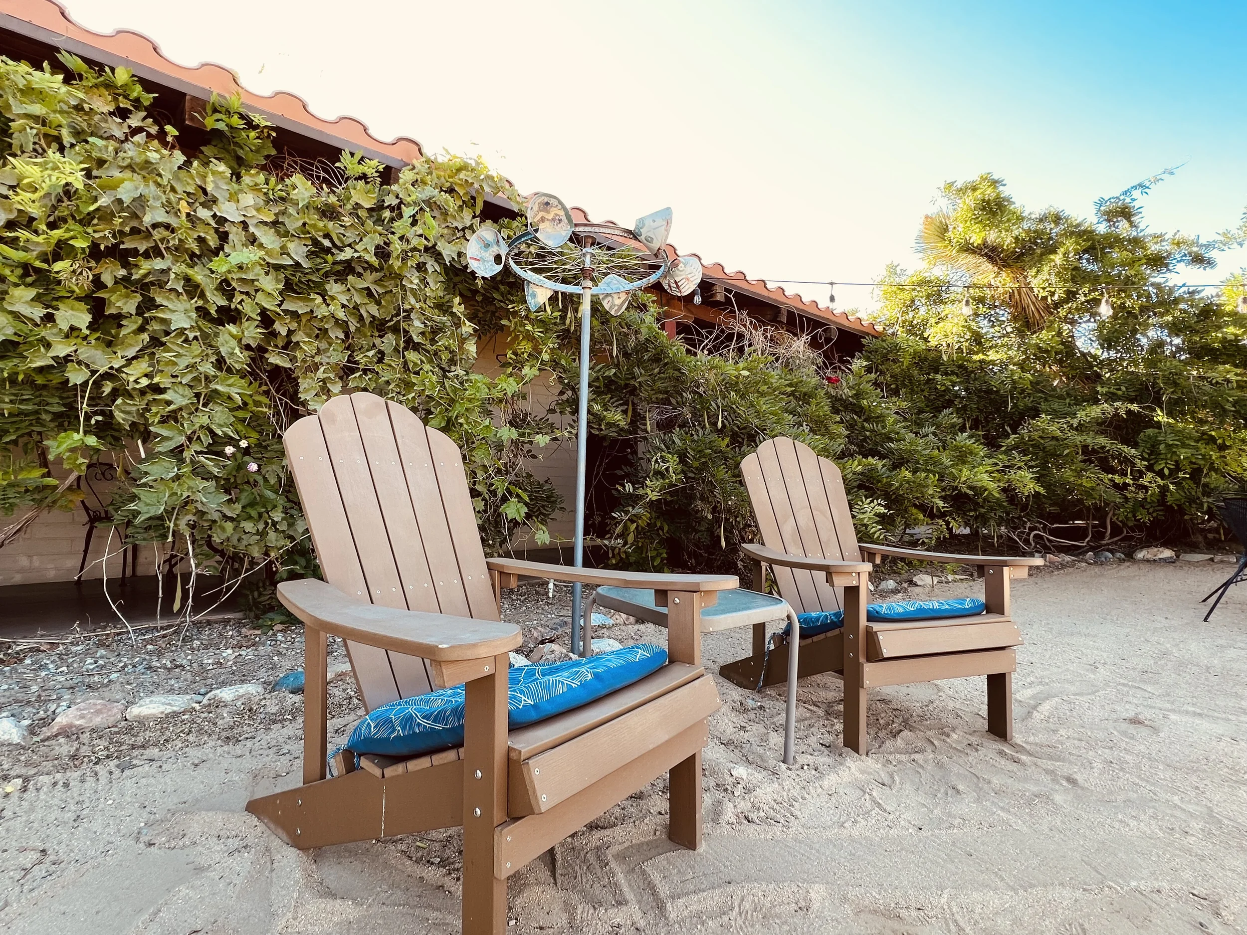 To chairs sitting Infront of the building in a cozy courtyard. 