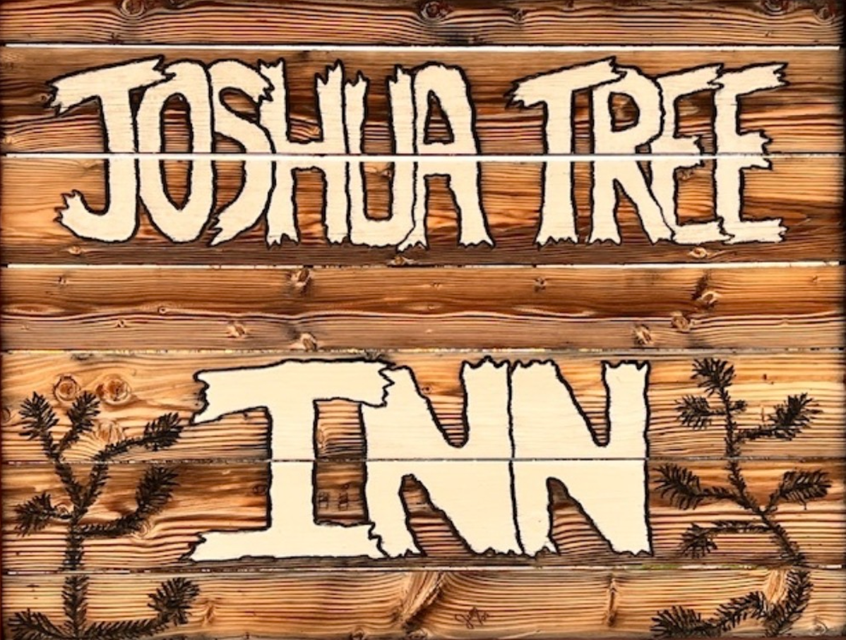 A wooden sign that Reads the Joshua Tree Inn